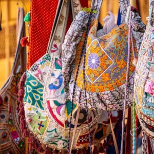 colorful-handmade-traditional-rajasthani-bags-mirrors-embroidery-tassels-hanging-outside-street-vendor-shop-ready-351887907